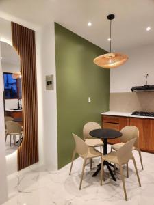 a dining room with a table and chairs and a green wall at Islander Suite in Puerto Baquerizo Moreno