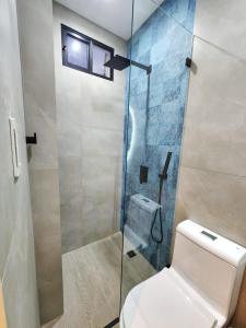 a bathroom with a toilet and a glass shower at Islander Suite in Puerto Baquerizo Moreno