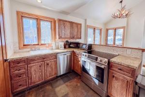 a kitchen with wooden cabinets and a sink at Benchmark Dr 101 ~ Guest House in Telluride