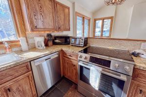 a kitchen with wooden cabinets and stainless steel appliances at Benchmark Dr 101 ~ Guest House in Telluride