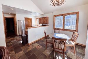 a kitchen with a table and chairs and a refrigerator at Benchmark Dr 101 ~ Guest House in Telluride