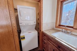 a small kitchen with a washer and dryer next to a sink at Benchmark Dr 101 ~ Guest House in Telluride +15 photos
