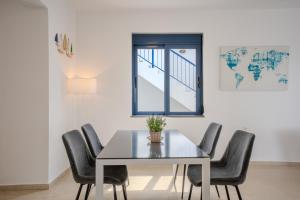 a dining room table with chairs and a window at Villa Salomon- Seafront Villa with Private Pool in Plaka