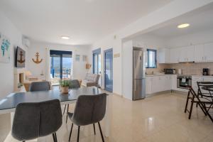 a kitchen and living room with a table and chairs at Villa Salomon- Seafront Villa with Private Pool in Plaka