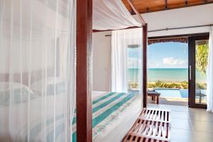 a bedroom with a bed and a view of the ocean at Pousada Spa dos Amores in São Miguel do Gostoso