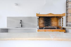 a kitchen with a brick fireplace and a sink at Villa Salomon- Seafront Villa with Private Pool in Plaka +54 photos