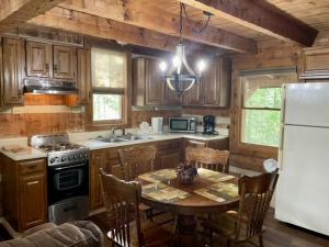 a kitchen with a table and a white refrigerator at Ivy Retreat in Sevierville +12 photos