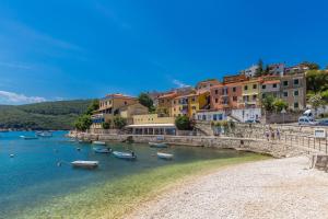 a group of boats in a body of water with buildings at Cozy holiday house CAPREE with pool in a quiet location near the beach Rabac in Ripenda Kras