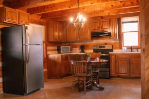 a kitchen with a refrigerator and a table in it at Trails End- Your Romantic Getaway Awaits! in Sevierville