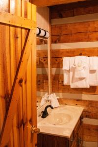 a bathroom with a sink in a log cabin at Trails End- Your Romantic Getaway Awaits! in Sevierville +13 photos