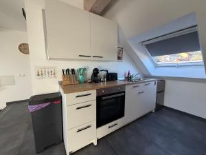 a small kitchen with white cabinets and a window at Mira Suites 3 in Schwalbach