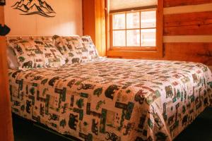 a bedroom with a bed with a quilt on it at Copeland Creek- Tiny Cabin in Sevierville