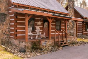 a log cabin with rocking chairs in the window at Bearfoot Bungalow- Tiny Cabin Getaway in Sevierville