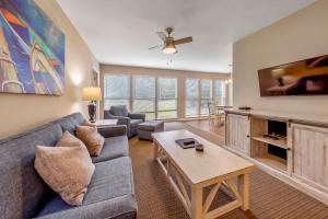 a living room with a couch and a table at Golf Course Condo with Pools & Family Fun in New Bern