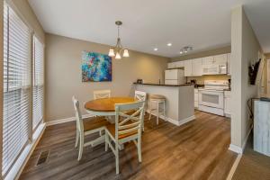 a kitchen and dining room with a table and chairs at Golf Course Condo with Pools & Family Fun in New Bern