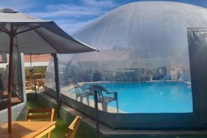a large swimming pool with an umbrella next to a table at Hotel Sebari in Villa Carlos Paz