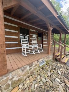 a porch of a cabin with white chairs on it at Lover's Leap in Sevierville +6 photos