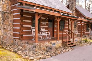 a log cabin with rocking chairs on the porch at Beary Cozy- Tiny Cabin Getaway! in Sevierville