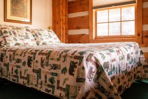 a bed in a room with a quilt on it at Beary Cozy- Tiny Cabin Getaway! in Sevierville