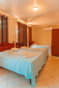 a hotel room with two beds in a room at Hotel Minas Brasil in Salinas
