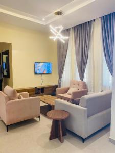 a living room with two couches and a tv at KIFA Stays in Laniya