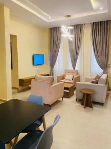 a living room with couches and a tv at KIFA Stays in Laniya