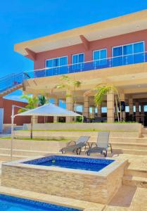 a building with two chairs and a swimming pool at Villa Barias in Baní
