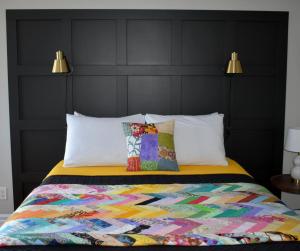 a bed with a colorful quilt and two pillows at Parkers Blue Water Inn in Pilleyʼs Island