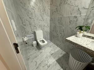 a bathroom with a toilet and a sink at Casaquinta overlooking the golf course in Concepción del Uruguay +28 photos