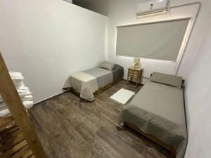 a small room with two beds and a window at Casaquinta overlooking the golf course in Concepción del Uruguay