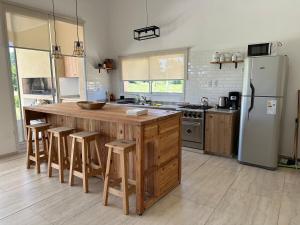 a kitchen with a large wooden island with bar stools at Casaquinta overlooking the golf course in Concepción del Uruguay
