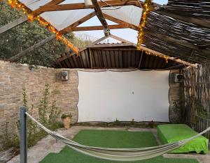 a hammock in a pergola with a white wall at Relajante Casa Atalaya in Cardiel de los Montes