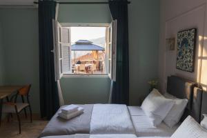 a bedroom with a bed and a window with a table at Mihail Residence - Old Town of Kavala in Kavála