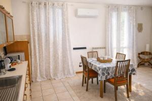 a kitchen with a table and chairs in a kitchen at La Corte Guesthouse appartamento indipendente con giardino privato in Cornate dʼAdda
