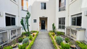 a walkway in front of a building with plants at Apto completo térreo 2quartos - praia e shopping in Rio das Ostras