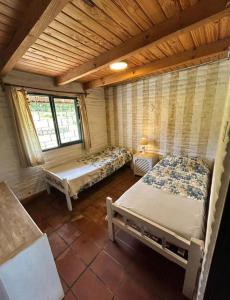 a room with two beds and two windows at Atahualpa Yupanqui 2 in Tafí del Valle