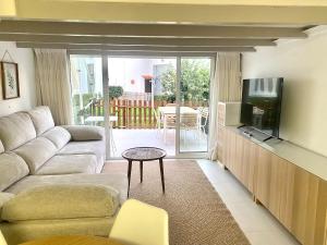a living room with a couch and a tv at Precioso bungalow con piscina en 1a Linea Playa in Denia