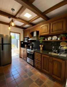 a kitchen with wooden cabinets and a stainless steel refrigerator at Atahualpa Yupanqui 2 in Tafí del Valle