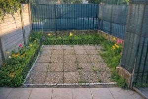 a garden with a fence and some flowers at La Corte Guesthouse appartamento indipendente con giardino privato in Cornate dʼAdda +1 photo