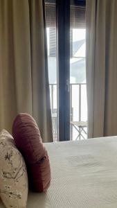 a pillow is sitting on a bed with a window at Estudio TAU in Jerez de los Caballeros