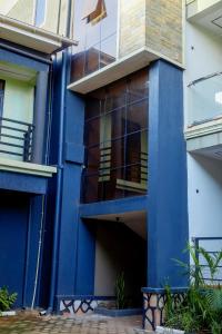 a blue building with a balcony on the side at Ham Apartments in Kampala +35 photos