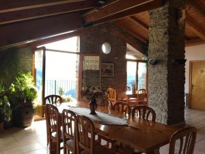 a dining room with a wooden table and chairs at Casa Camp in Enviny