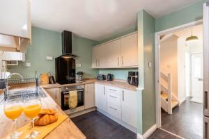 a kitchen with two glasses of orange juice on a counter at Modern 3BR Durham Stay for Work Trips in Brandon