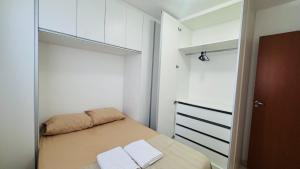 a small bedroom with a bed and a closet at Apto completo térreo 2quartos - praia e shopping in Rio das Ostras +31 photos