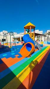 a playground with a slide on a colorful carpet at Apto completo térreo 2quartos - praia e shopping in Rio das Ostras