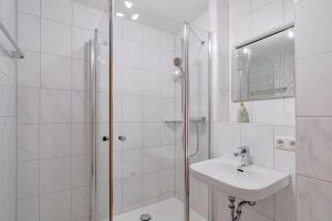 a white bathroom with a shower and a sink at Fewo Barth in Bad Hindelang