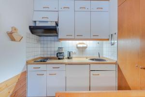 a kitchen with white cabinets and a sink at Fewo Barth in Bad Hindelang