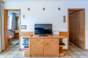 a living room with a television on a wooden desk at Fewo Barth in Bad Hindelang