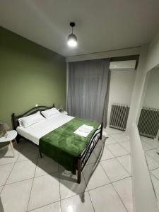 a bedroom with a bed with a green blanket on it at A&S Luxury Apartment in Kavála
