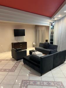 a living room with two couches and a flat screen tv at A&S Luxury Apartment in Kavála